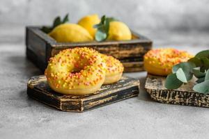Delicious fresh donuts in yellow glaze with lemon flavor filling photo
