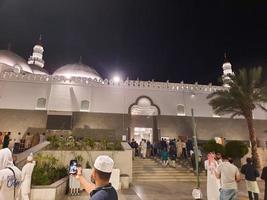 Medina, Saudi Arabia, April 2023 - A beautiful view of the building and minarets  of the Quba Mosque in Medina, Saudi Arabia at night. photo