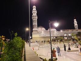 Medina, Saudi Arabia, April 2023 - A beautiful view of the building and minarets  of the Quba Mosque in Medina, Saudi Arabia at night. photo