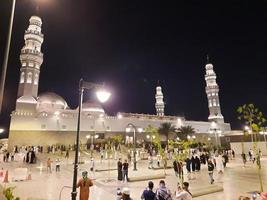 Medina, Saudi Arabia, April 2023 - A beautiful view of the building and minarets  of the Quba Mosque in Medina, Saudi Arabia at night. photo