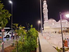 Medina, Saudi Arabia, April 2023 - A beautiful view of the building and minarets  of the Quba Mosque in Medina, Saudi Arabia at night. photo