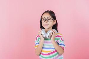 Asia little girl cute put on headphones have video call distant class with teacher using laptop, study online on computer, homeschooling concept photo