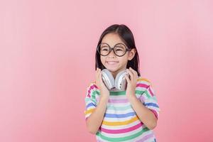 Asia little girl cute put on headphones have video call distant class with teacher using laptop, study online on computer, homeschooling concept photo