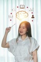 A woman is holding a drawing of a brain with the words brain on it photo