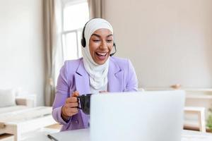 Muslim Business woman with headsets working with computer at office. Customer service assistant working in office.woman operator working with headsets and laptop at telemarketing customer service. photo