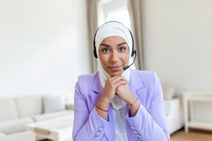 Muslim Business woman with headsets working with computer at office. Customer service assistant working in office.woman operator working with headsets and laptop at telemarketing customer service. photo