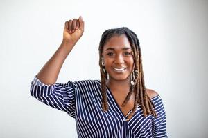 elevado mano de joven africano mujer apretado dentro puños en ligero antecedentes. detener racismo concepto foto