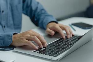 Man typing on keyboard laptop computer, searching for information or doing freelance work.Digital technology online network and social media concept. photo