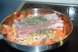 Bacon with Carrots, Apple and Herbs in a pan photo