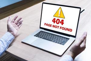 Businessman spread out your hands with attention icon and message 404 PAGE NOT FOUND on display laptop photo