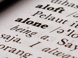 a close up of the word alone in the English to Indonesian dictionary. For word background or wallpaper photo