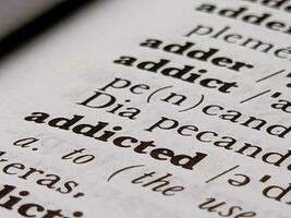 a close up of the word addicted in the English to Indonesian dictionary. For word background or wallpaper photo