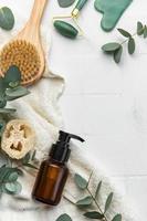 Spa treatment concept. natural spa cosmetics products with eucalyptus oil,, massage brush, eucalyptus leaf. photo