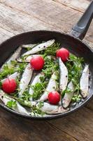 Smelt fishes in old pan photo