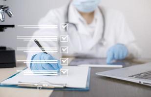 hembra médico utilizando tomando un evaluación, cuestionario, evaluación, en línea encuesta, prescripción o firma médico reporte o médico certificado o salud chequeo formar documentos en hospitales foto