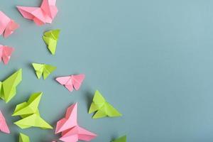 Paper butterfies green and pink color flat lay on a colored background. Lightness, spring beauty concept photo