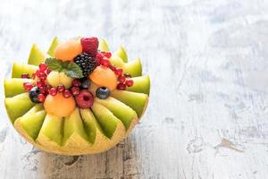 Sliced melon with berry fruit photo