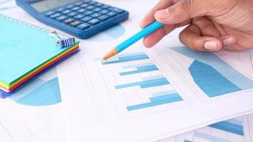 Man hand with pen analyzing bar chart on paper video