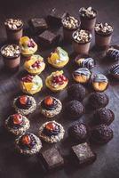 Assorted mini cakes on wooden background photo