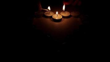 brûlant bougies dans forme de une cœur avec lumière de feu, bougies' Feu création une symbolique image pour romantique ambiance video