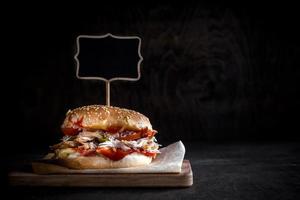 Chicken burger with sliced meat and chalkboard photo