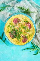 Omelette with sausage, herbs and grated cheese. Easy breakfast. Top view photo