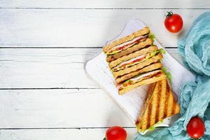 Club sandwich with ham, tomato, green and cheese. Grilled panini. Top view photo