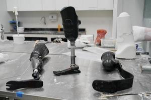 Orthopedic technician making prosthetic leg for disabilities people in workshop. photo