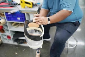 Orthopedic technician making prosthetic leg for disabilities people in workshop. photo