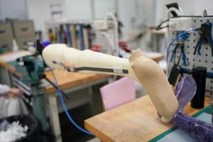 Orthopedic technician making prosthetic leg for disabilities people in workshop. photo