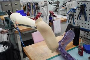 Orthopedic technician making prosthetic leg for disabilities people in workshop. photo