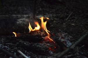 ardiente madera registros en el noche. borroso ligero. brillante rojo fuego. naturaleza fotografía. foto