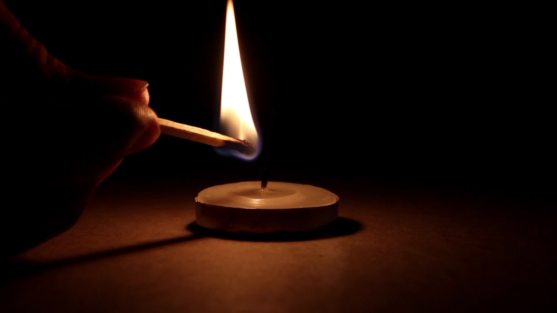 Lighting candle in dark atmosphere, small and beautiful looking candle