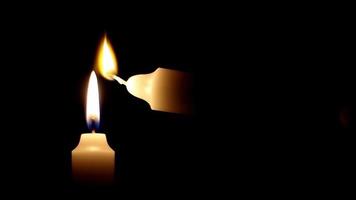 Kerze Licht auf schwarz Hintergrund, Licht ein Neu Kerze mit das Feuer von das Verbrennung Kerze, selektiv Fokus video