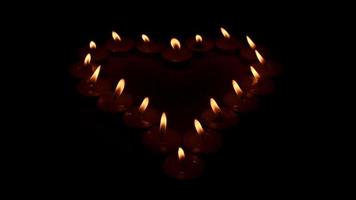 candele creare simbolico senso di amore con candela incendi, romantico ambiance è creato di leggero di a forma di cuore candele, selettivo messa a fuoco video