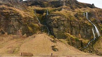 gljufrabui, Island, 2023 - - Tourist erreichen im nass Bedingungen gljurfrabui Wasserfall. klein Wasserfall durch seljalandsfoss video