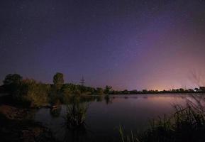 ver en estrellado noche cielo encima lago foto