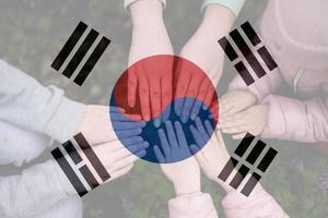 Hands of kids on background of South Korea flag. South Korean patriotism and unity concept. photo