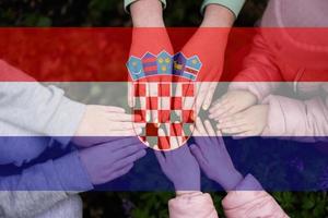 Hands of kids on background of Croatia flag. Croatian patriotism and unity concept. photo