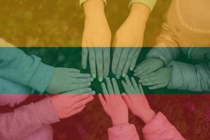 Hands of kids on background of Lithuania flag. Lithuanian patriotism and unity concept. photo