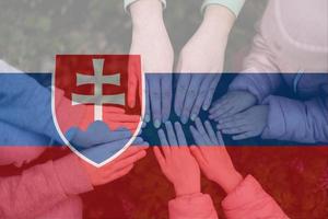 Hands of kids on background of Slovakia flag. Slovakian patriotism and unity concept. photo