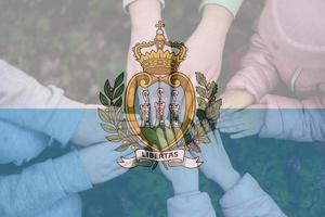 Hands of kids on background of San Marino flag. Sammarinese patriotism and unity concept. photo
