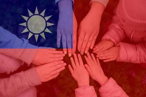 Hands of kids on background of Taiwan flag. Taiwanese patriotism and unity concept. photo