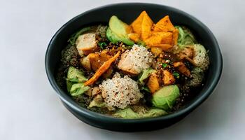 Vegan bowl quinoa avocado pumpkin with beans and corn in a black bowl. photo