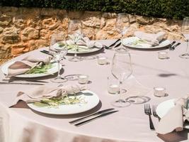 Table at luxury wedding reception event. Beautiful flowers on table and serving dishes and glasses and decoration photo