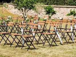 Wedding decoration chairs in rustic green style. Wedding ceremony outdoors photo