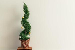 Indoor cypress or thuja in pot is decorating balls like Christmas tree. Alternative trees for christmas . Copy space and space for advertising photo