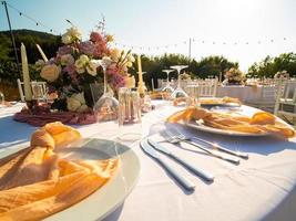 mesa a lujo Boda recepción evento. hermosa flores en mesa y servicio platos y lentes y decoración foto