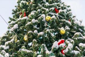 Close up decorated christmas tree balls bauble and New Year's garlands on outside in town square - xmas and winter holidays in cityscape photo