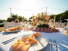 Wedding banquet concept. Chairs and round table for guests, served with cutler and, flowers and crockery and covered with a tablecloth photo
